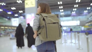 Yavaş hareket - Uluslararası Havaalanı Kalkış kapısında yatılı uçuşa giderken terminal salonunda yürüyen genç Asyalı backpacker kadın. Yaşam tarzı sırt çantası turizm seyahat tatil kavramı.