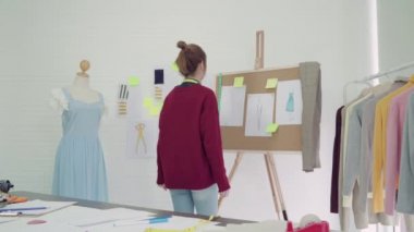 Profesyonel güzel Asyalı kadın moda kumaş çizimler ile çalışma ve stüdyoda giyim tasarım çizim tasarımcı. Yaşam tarzı kadın kavramı çalışma.