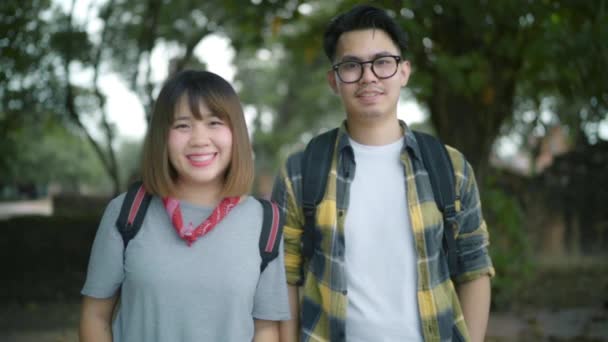 スローモーション 旅行アジア カップル カメラ旅行でタイに笑顔幸せな気持ち バックパッカーの甘いカップルを楽しむ伝統的な都市の素晴らしいランドマークで彼らの旅 — ストック動画