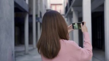 Yavaş hareket - şehrin güzel turistik erkek smartphone kullanarak fotoğraf için tatil seyahat ederken yürüyen genç Asyalı blogger kadın. Yaşam kadın sakin şehir kavramı.
