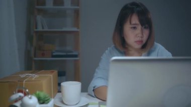 Güzel akıllı Asya genç girişimci iş kadın sahibi KOBİ online ürün stok kontrol ve gece eve geç çalışan bilgisayara kaydedin. Küçük işletme sahibi, ev ofis kavramı.