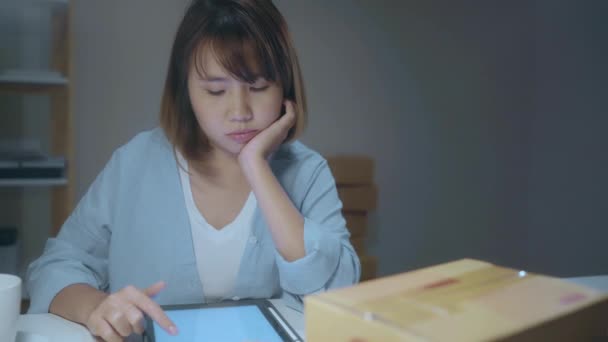 年轻的亚洲企业家女老板 在线检查产品的库存和保存到平板电脑在家里晚上工作 感到恶心和疲惫 小企业主在家里的办公室概念 — 图库视频影像