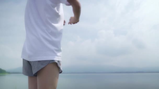 亚洲跑步女双腿温暖和伸展她的手臂准备在街上跑步 健康的年轻美丽的女性运动附近的湖泊 生活方式适合和积极的妇女在街头的概念锻炼 — 图库视频影像