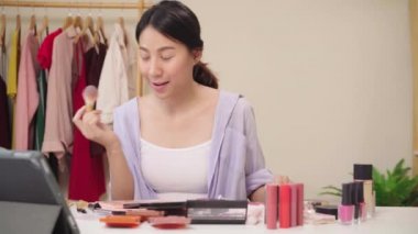 Önde oturan güzellik blogger mevcut güzellik kozmetik için video kayıt tablet. Asyalı kadın kullanım kozmetik inceleme yapmak öğretici mutlu güzel genç sosyal ağ için canlı video yayını.