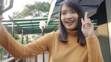Bangkok, Tayland şehir merkezinde seyahat ederken selfie alarak akıllı telefon kullanarak Neşeli güzel genç Asya backpacker blogger kadın. Yaşam çantası turist seyahat tatil konsepti.