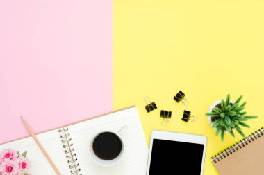 Ofis Masası adlı kullanıcının alanı - düz çalışma üstten görünüm fotoğraf çalışma alanı boş sahte tablet, kahve fincanı ve defter pastel zemin üzerine yatırın. Pastel pembe sarı renkli kopya alanı çalışma Resepsiyon kavramı.