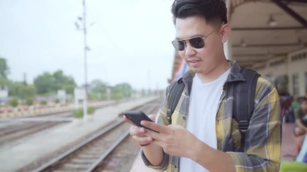 Asiatiska Ryggsäck Mannen Tågstationen Unga Manliga Turist Backpacker Använda Mobiltelefon — Stockvideo