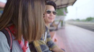 Gezgin Asya sırt çantası çift tren beklerken bankta oturan, Genç tatlı çift turist backpacker Tayland kendi yolculuk keyfini çıkarın. Yaşam tarzları genç çift dinlenmek ve seyahat kavramı.