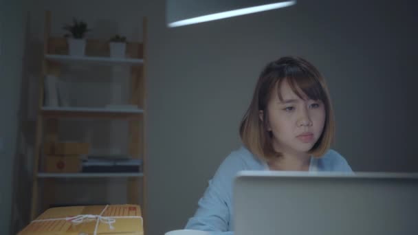 Gyönyörű ázsiai intelligens fiatal vállalkozó nő cégtulajdonos a KKV-k online termék állomány ellenőrzése, és mentse a számítógép késő este otthon dolgozik. Kisvállalkozás tulajdonosa, otthoni iroda koncepció:.