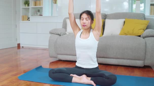 リビングでヨガを練習している若いアジア人女性 自宅で健康のために働く魅力的な美しい女性 ライフスタイル女性運動の概念 — ストック動画