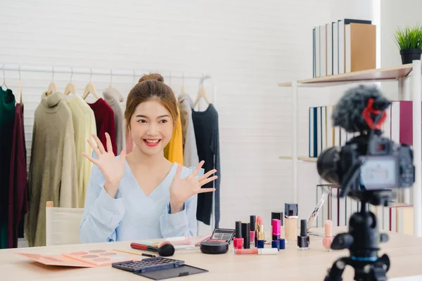 Skjønnhetsblogger presenterer skjønnhetskosmetikk foran kamera for opptak av video. Vakker asiatisk kvinne bruker kosmetikk mens anmeldelse utgjør en veiledende direktesending til sosialt nettverk via Internett . – stockfoto