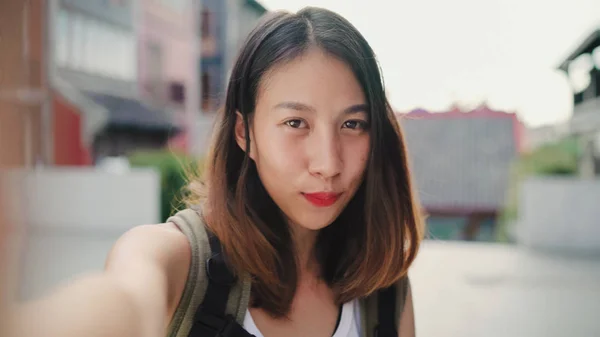Vrolijke mooie jonge Aziatische backpacker blogger vrouw met behulp van smartphone selfie te nemen terwijl het reizen in Chinatown in Peking, China. Levensstijl rugzak concept van toeristische reizen vakantie. Point of view. — Stockfoto