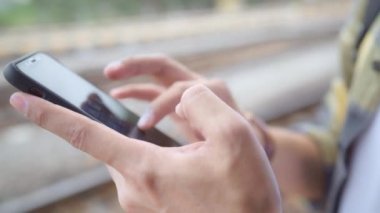 Tren istasyonunda Asya sırt çantası adam, Tayland kendi yolculuğunda cep telefonu görünümlü ve yön haritaları kullanarak Genç erkek turist backpacker. Yaşam tarzları erkekler dinlenmek ve seyahat kavramı.