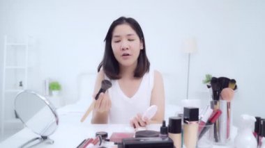 Güzellik blogger video kayıt için kamera önünde oturan güzellik kozmetik mevcut. Asyalı kadın kullanım kozmetik inceleme yapmak öğretici mutlu güzel genç sosyal ağ için canlı video yayını.