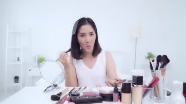 Güzellik blogger video kayıt için kamera önünde oturan güzellik kozmetik mevcut. Asyalı kadın kullanım kozmetik inceleme yapmak öğretici mutlu güzel genç sosyal ağ için canlı video yayını.