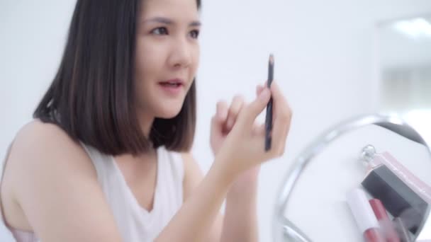 美容ブロガーは ビデオ録画のためのカメラの前に座って美容化粧品を紹介します 幸せな美しい若いアジア女性使用化粧品レビューは チュートリアルを構成するソーシャル ネットワークに放送します — ストック動画