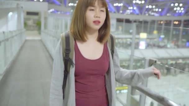 国際空港の出発ゲートで搭乗便に通いながらターミナル ホールで歩く若いアジアのバックパッカーの女性観光客 ライフ スタイル バックパック観光旅行休暇の概念 — ストック動画