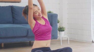 Genç Asyalı kadın oturma odasında yoga yapıyor. Çekici, güzel bir kadın evde sağlıklı bir yaşam için çalışıyor. Yaşam tarzı kadın egzersiz konsepti.