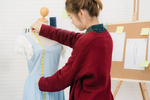 Professionella vackra asiatiska kvinnliga mode designer arbetar mäta klänning på en skyltdocka kläddesign på studio. Livsstil-kvinnor som arbetar koncept. — Stockfoto