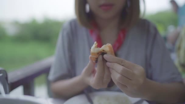 慢动作 年轻的亚洲妇女吃虾海鲜在餐厅 青少年女性感觉快乐吃的食物 女性吃海鲜概念 — 图库视频影像