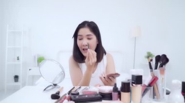 Güzellik blogger video kayıt için kamera önünde oturan güzellik kozmetik mevcut. Asyalı kadın kullanım kozmetik inceleme yapmak öğretici mutlu güzel genç sosyal ağ için canlı video yayını.