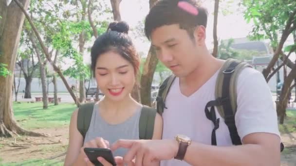 旅客亚洲夫妇的方向位置地图上的位置地图 夫妇使用手机看地图找到地标 而花费度假之旅 生活方式夫妇旅行在城市概念 — 图库视频影像