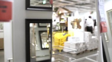 Genç Asyalı kadın depoda yeni mobilya seçerek alışveriş sepeti sürmek, genç kadın mağazada raflar önünde mutlu hissediyorum. Kadınlar alışveriş yeni mobilya konsepti.