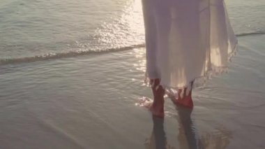 Yavaş çekim - Genç Asyalı kadın sahilde yürüyüş. Güzel kadın mutlu akşam gün batımı nda deniz kenarında sahilde yürüyüş rahatlayın. Yaşam tarzı kadın plaj konsepti seyahat.