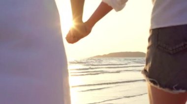 Genç Asyalı lezbiyen çift sahilde koşuyor. Güzel kadın arkadaşlar mutlu akşam gün batımında deniz kenarında plajda eğlenmek. Plaj konsepti lifestyle lezbiyen çift seyahat.