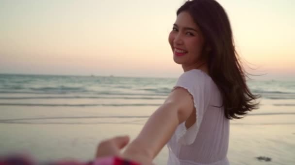 慢动作 年轻的亚洲夫妇在沙滩上跑步和玩耍 甜蜜的情侣有浪漫的时间 而蜜月之旅在海边的海滩 当日落在晚上 生活方式夫妇旅行海滩概念 — 图库视频影像