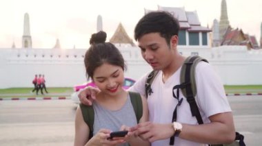 Bangkok, Tayland, gün batımında tatil gezisi geçirirken harita ya bakarak cep telefonu kullanarak tatlı çift yer haritası üzerinde Gezgin Asya çift yön. Şehir konseptinde yaşam tarzı çift seyahat.