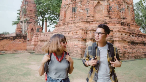 Traveler Asian couple spending holiday trip at Ayutthaya, Thailand, backpacker sweet couple enjoy their journey at amazing landmark in traditional city. Lifestyle couple travel holidays concept.