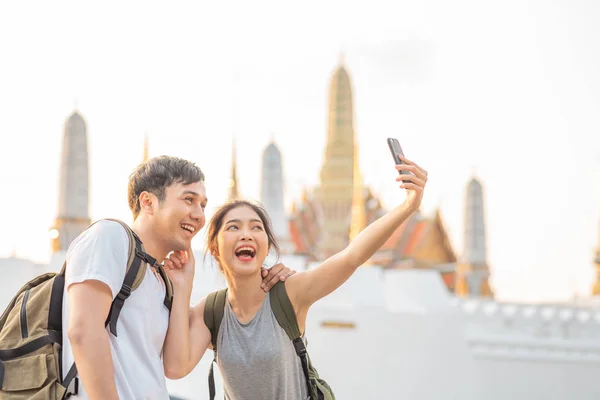 Aasialainen bloggaaja pari matkustaa Bangkokissa, Thaimaassa, makea pari matkapuhelimella selfie ja valokuva näkymä viettäessään makeaa aikaa lomamatkalla auringonlaskussa. Pari matkustaa kaupungin käsite . — kuvapankkivalokuva