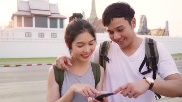 慢动作 旅行亚洲夫妇的方向的位置地图上的位置地图在曼谷 甜蜜的夫妇使用手机寻找地图 而花度假之旅在日落 生活方式夫妇旅行概念 — 图库视频影像