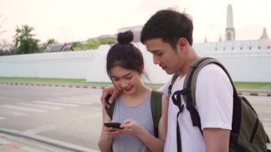Bangkok, Tayland, gün batımında tatil gezisi geçirirken harita ya bakarak cep telefonu kullanarak tatlı çift yer haritası üzerinde Gezgin Asya çift yön. Şehir konseptinde yaşam tarzı çift seyahat.