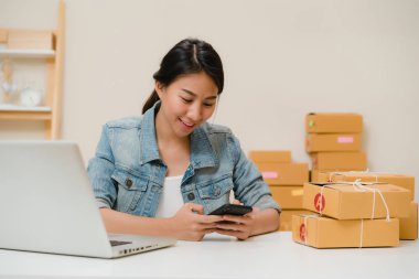 Güzel akıllı Asya genç girişimci iş kadın KOBİ ürün evde çalışan hisse senedi tarama qr kod üzerinde kontrol sahibi. Küçük işletme sahibi, ev ofis kavramı.