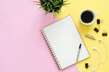 Yaratıcı düz fotoğraf çalışma masası yatıyordu. Üstten Görünüm Ofis Masası sahte kadar dizüstü bilgisayarlar, bitki, pastel renkli arka plan üzerinde kahve Kupası ve kopya alanı ile. Kopya alanı, düz yatıyordu fotoğraf ile Üstten Görünüm.