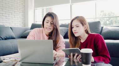 Lezbiyen Asyalı çift evde oturma odasında bütçe yapma dizüstü bilgisayar kullanarak, tatlı çift evde rahat zaman kanepede yatarken aşk anın tadını çıkarın. Yaşam tarzı çift evde kavramı relax.