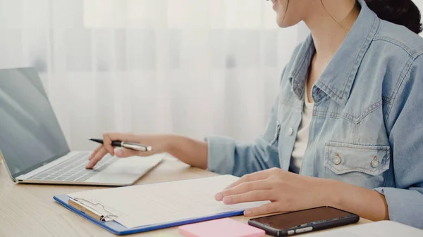 Mooie slimme Aziatische jonge ondernemer de eigenaar van de vrouw van het bedrijf van KMO controleren product op voorraad en schrijven over het klembord werken thuis. Kleine ondernemer op kantoor aan huis concept. — Stockfoto