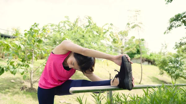 Sano bella giovane atleta asiatica donne in abbigliamento sportivo gambe riscaldando e allungando le braccia a pronto per la corsa in strada nel parco urbano della città. Stile di vita donne attive esercizio nel concetto di città . — Foto Stock