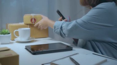 Sme online stok ürün kontrol ve cep telefonu evde gece geç saatlerde çalışan kaydetmek Akıllı Asya genç girişimci iş kadını sahibi. Ev ofis konseptinde küçük işletme sahibi.