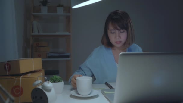 亚洲年轻企业家的女老板Sme在线检查产品的股票节省到电脑和喝咖啡工作深夜在家里 小型企业所有者在家庭办公室的概念 — 图库视频影像