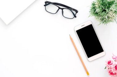 Yaratıcı düz çalışma alanı masasının fotoğraf yatıyordu. Telefon, kalem, gözlük ve beyaz renkli arka plan üzerinde bitki ile üst görünüm ofis masası. Kopyalama alanı ile üst görünüm, düz döşeme fotoğraf.