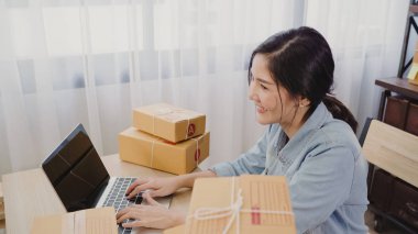 Güzel akıllı Asya genç girişimci iş kadın sahibi KOBİ online ürün stok kontrol ve bilgisayar evde çalışma için kaydedin. Küçük işletme sahibi, ev ofis kavramı.
