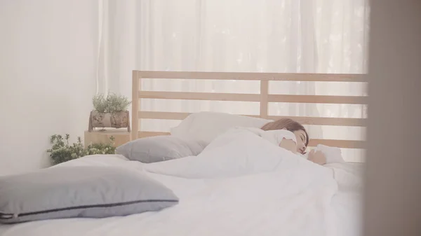 Donna asiatica sognando mentre dorme sul letto in camera da letto, Bella femmina giapponese utilizzando il tempo di relax sdraiato sul letto a casa. Stile di vita delle donne che utilizzano il tempo di relax a casa concetto . — Foto Stock