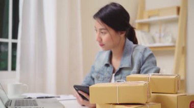 Sme online stok ürün kontrol ve evde çalışan dizüstü bilgisayara tasarruf Akıllı Asya genç girişimci iş kadını sahibi. Ev ofis konseptinde küçük işletme sahibi.