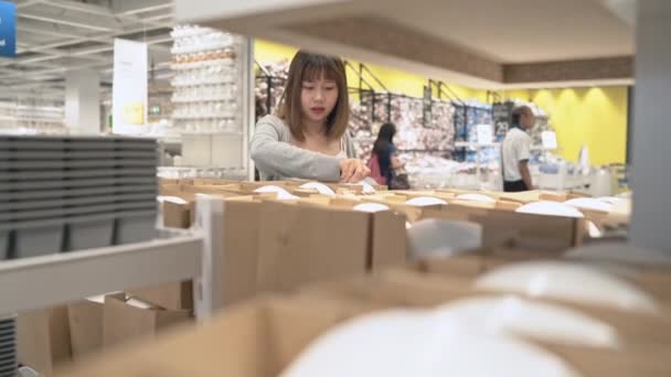 Young Asian Woman Rides Shopping Cart Choosing New Furniture Warehouse — Stock Video