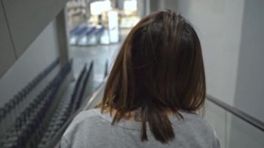Genç Asyalı kadın depoda yürüyen merdiven kullanarak, genç kadın mağazada yeni mobilya seçerken mutlu hissediyorum. Kadınlar alışveriş yeni mobilya konsepti.