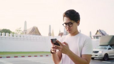 Bangkok, Tayland, backpacker erkek gün batımında tatil gezisi geçirirken harita üzerinde bakarak cep telefonu kullanarak konum haritası üzerinde Gezgin Asya adam yön. Yaşam tarzı erkekler Asya şehir kavramı seyahat.