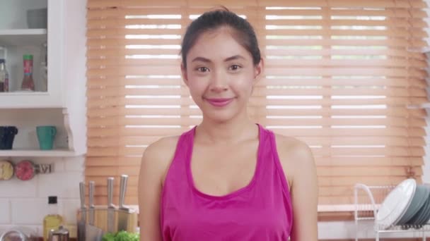 若いアジアのブロガーの女性の運動とキッチンでカメラを探して 魅力的な美しい女性は 自宅で健康のために働いています 家庭での女性運動 — ストック動画